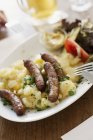 Sausages on bed of potato salad — Stock Photo