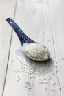 Uncooked rice on spoon — Stock Photo