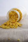 Cornflakes falling out of jar — Stock Photo