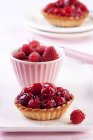 Raspberry tartlet and fresh raspberries — Stock Photo