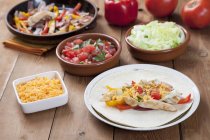Chicken Fajita on a Plate Fillings in Background over wooden surface — Stock Photo