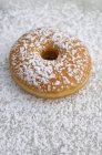 Donut polvilhado com açúcar de confeiteiro — Fotografia de Stock