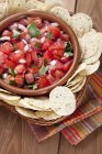 Schüssel mit frischer Salsa mit Tortilla-Chips über Holzoberfläche — Stockfoto
