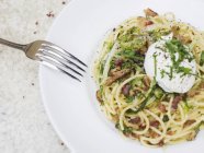 Спагетти карбонара с яйцом-браконьером — стоковое фото