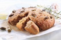 Pan de focaccia con aceitunas y romero - foto de stock