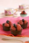 Closeup view of chocolate bowls with raspberries and ganache — Stock Photo