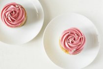 Dois cupcakes decorados com creme de morango — Fotografia de Stock