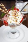 Nahaufnahme von Erdbeer-Eisbecher mit Sahne und Waffeln — Stockfoto
