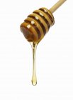 Honey dripping from dipper — Stock Photo