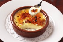 Closeup view of Creme brulee on spoon and in bowl — Stock Photo