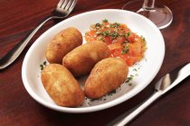 Картофельные крокеты с томатным соусом на белой тарелке — стоковое фото
