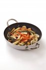 Stir-fried vegetables with rosemary in frying pan on white surface — Stock Photo
