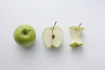 Manzana fresca entera y cortada a la mitad - foto de stock