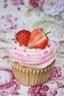 Strawberry cupcake on table cloth — Stock Photo