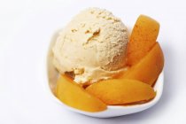 Apricot ice cream garnished with apricot wedges — Stock Photo