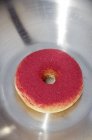 Doughnut dusted with colored sugar powder — Stock Photo