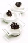 Closeup view of blackberries and cream in small white bowls — Stock Photo
