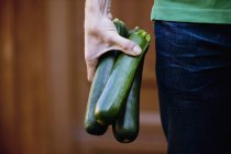 Mann hält Zucchini in der Hand — Stockfoto