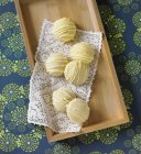 Top view of lemon cookies on doily and wooden tray — Stock Photo