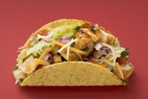 Closeup view of chicken Taco on red surface — Stock Photo