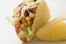 Taco gefüllt mit Zuckermais und Bohnen auf weißer Oberfläche — Stockfoto