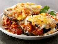 Gratinated aubergines with tomato sauce  on white plate — Stock Photo