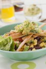 Салат, бобы, кукуруза, тортилья и гуакамоле в голубой тарелке — стоковое фото