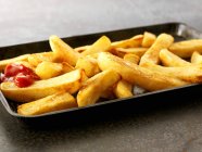 Ketchup em batatas fritas — Fotografia de Stock