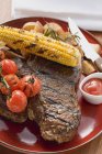Grilled steak on red plate — Stock Photo