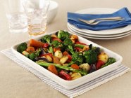 Жареные овощи на белой тарелке над полотенцем на столе — стоковое фото
