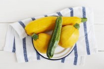 Yellow and green courgettes on plate — Stock Photo