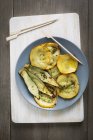 Erhaltene Zucchini auf grauem Teller über Schreibtisch — Stockfoto