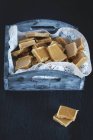 Vue rapprochée des bonbons à la crème faits maison dans un plateau en bois — Photo de stock
