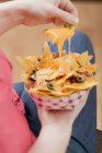 Hand taking nachos — Stock Photo