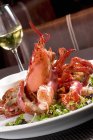Closeup view of whole lobster with fresh greens on plate — Stock Photo