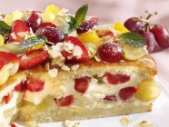 Closeup view of fruit gateau with grapes and mint leaves — Stock Photo