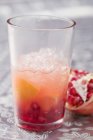 Closeup view of fruity drink with orange and pomegranate — Stock Photo