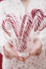 Woman holding candy canes — Stock Photo
