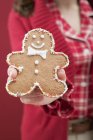 Hand holding gingerbread man — Stock Photo