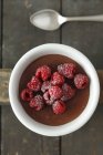 Chocolate pudding topped with raspberries — Stock Photo