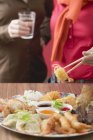 Vista cortada de duas mulheres com prato de aperitivos asiáticos — Fotografia de Stock