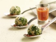 Spinach dumplings with tomato sauce over white surface — Stock Photo