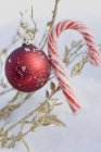 Christmas bauble and candy cane — Stock Photo
