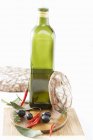 Bottle of olive oil with olives and chillies — Stock Photo