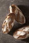 Vue du dessus de trois pains de campagne — Photo de stock