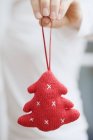 Hands holding Christmas tree ornament — Stock Photo