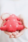 Hands holding Christmas tree ornament — Stock Photo