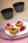 Closeup view of Financiers with chocolate and raspberries on plate — Stock Photo
