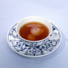 Thé avec cristaux de sucre en tasse et soucoupe — Photo de stock