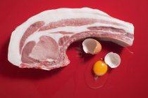 Costeleta de porco orgânica e ovo quebrado — Fotografia de Stock